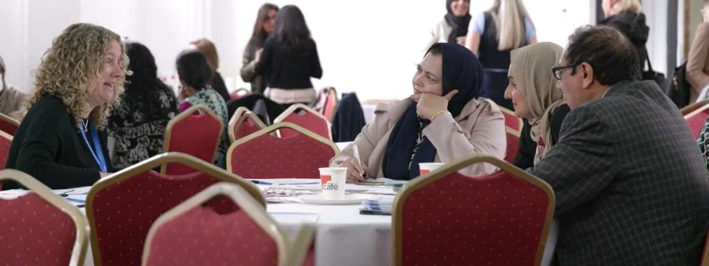 Three people talking at a table at the festival.